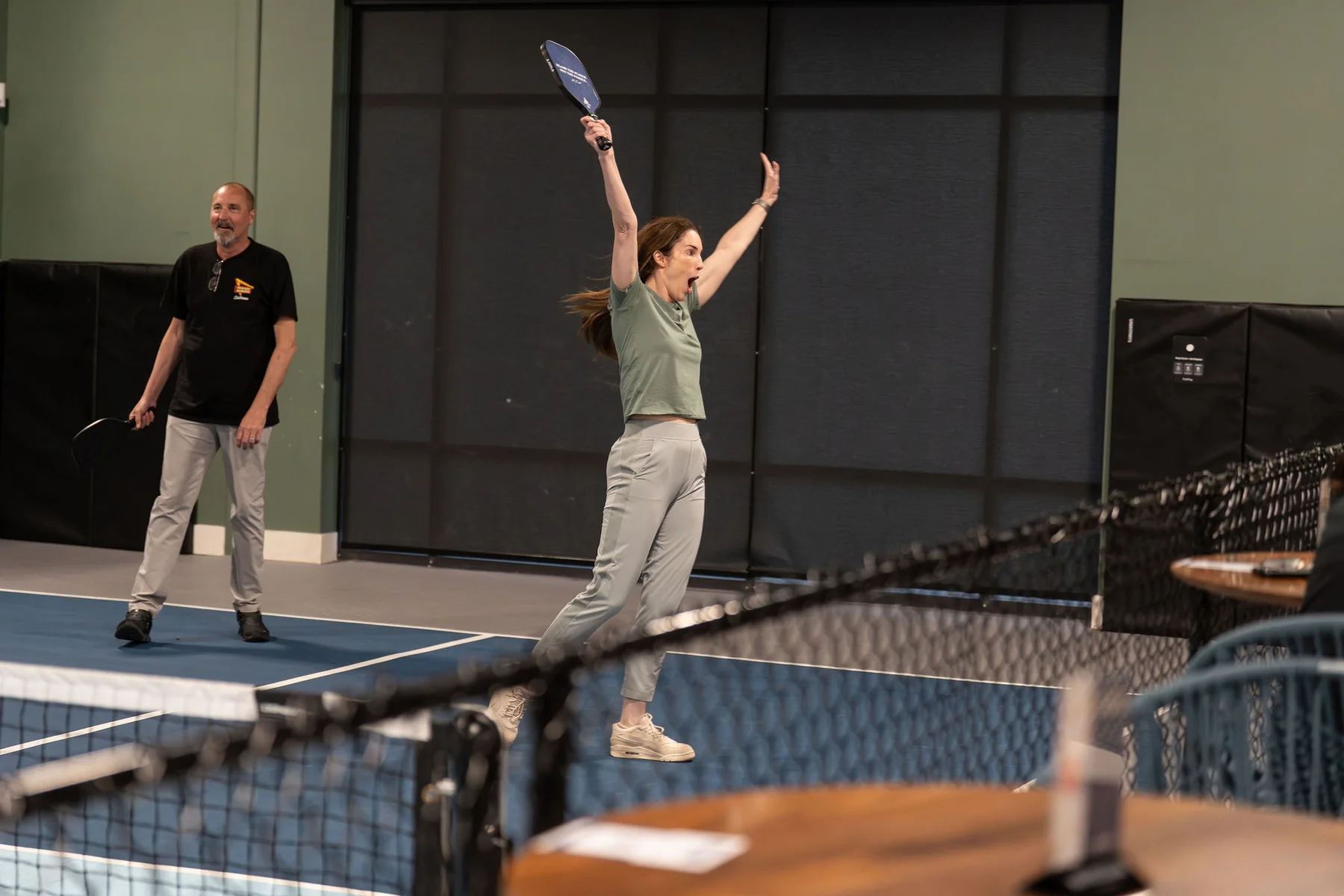 A guest celebrates after a point on the pickleball court