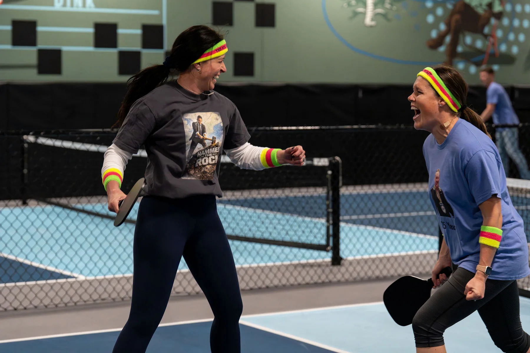 Two pickleball players congratulate each other after a point at At Fault